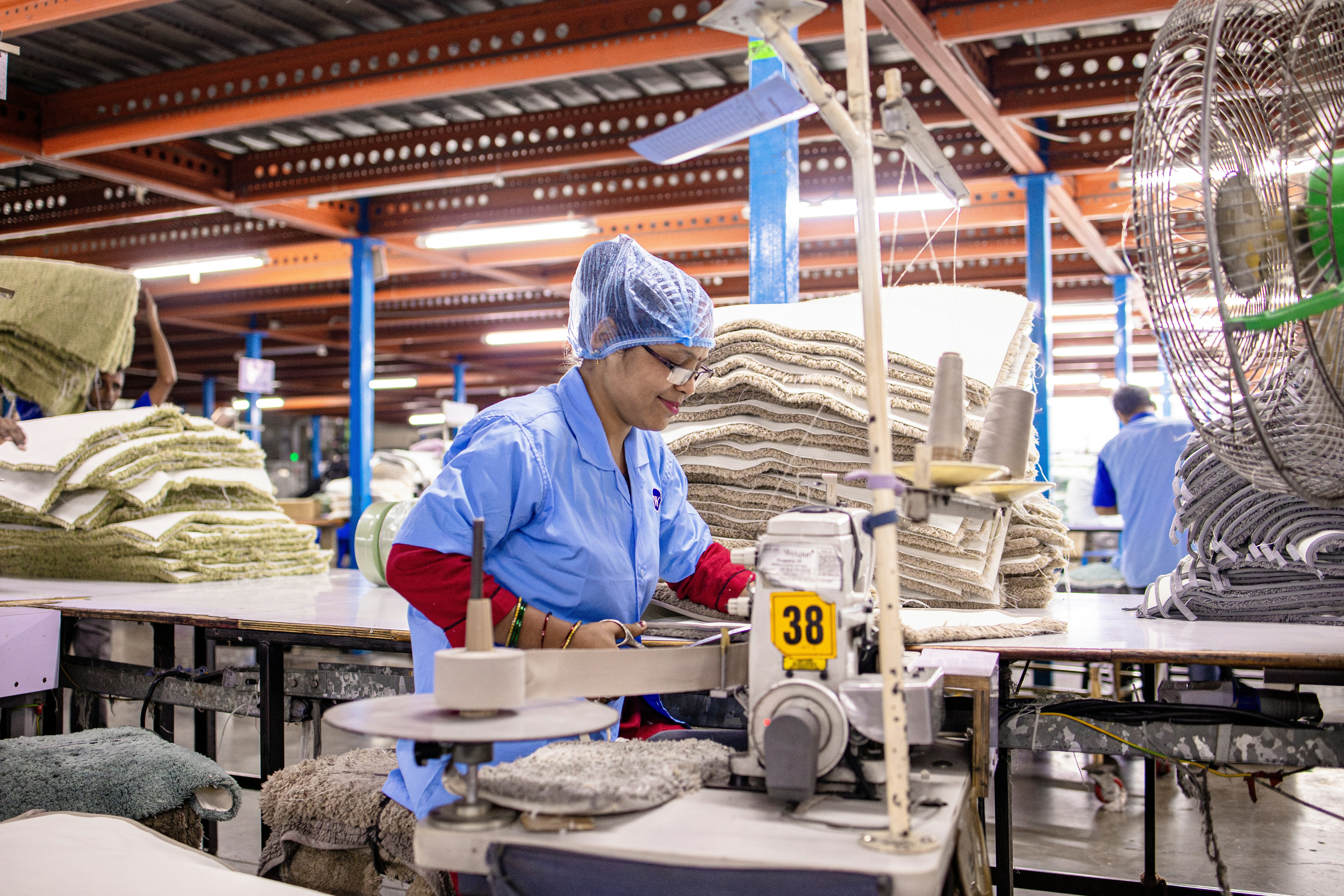 Woman seams fabric in a textile factory.