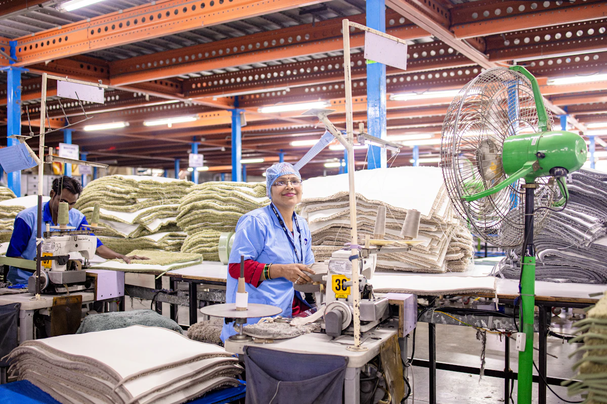 Garment workers sewing fabric along a factory production line