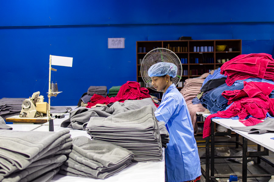 A worker inspecting finished garments before packing