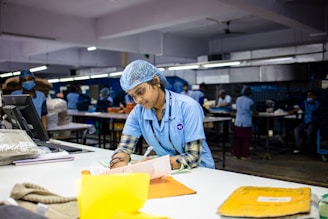 Factory worker writing at a desk.