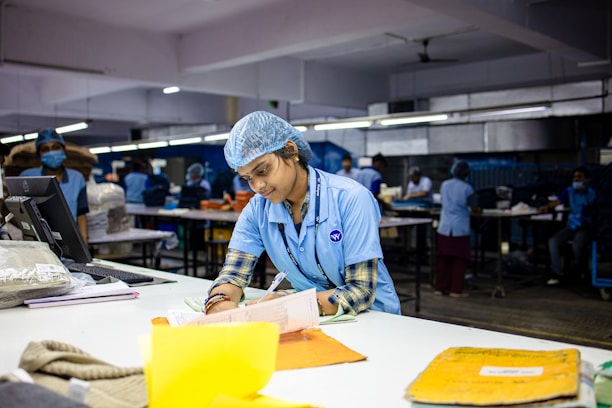 Factory worker writing at a desk.