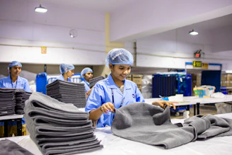 Workers in a factory folding and organizing towels.