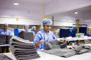 Workers in a factory folding and organizing towels.