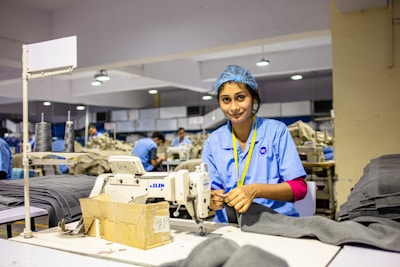 A woman sews fabric in a factory.