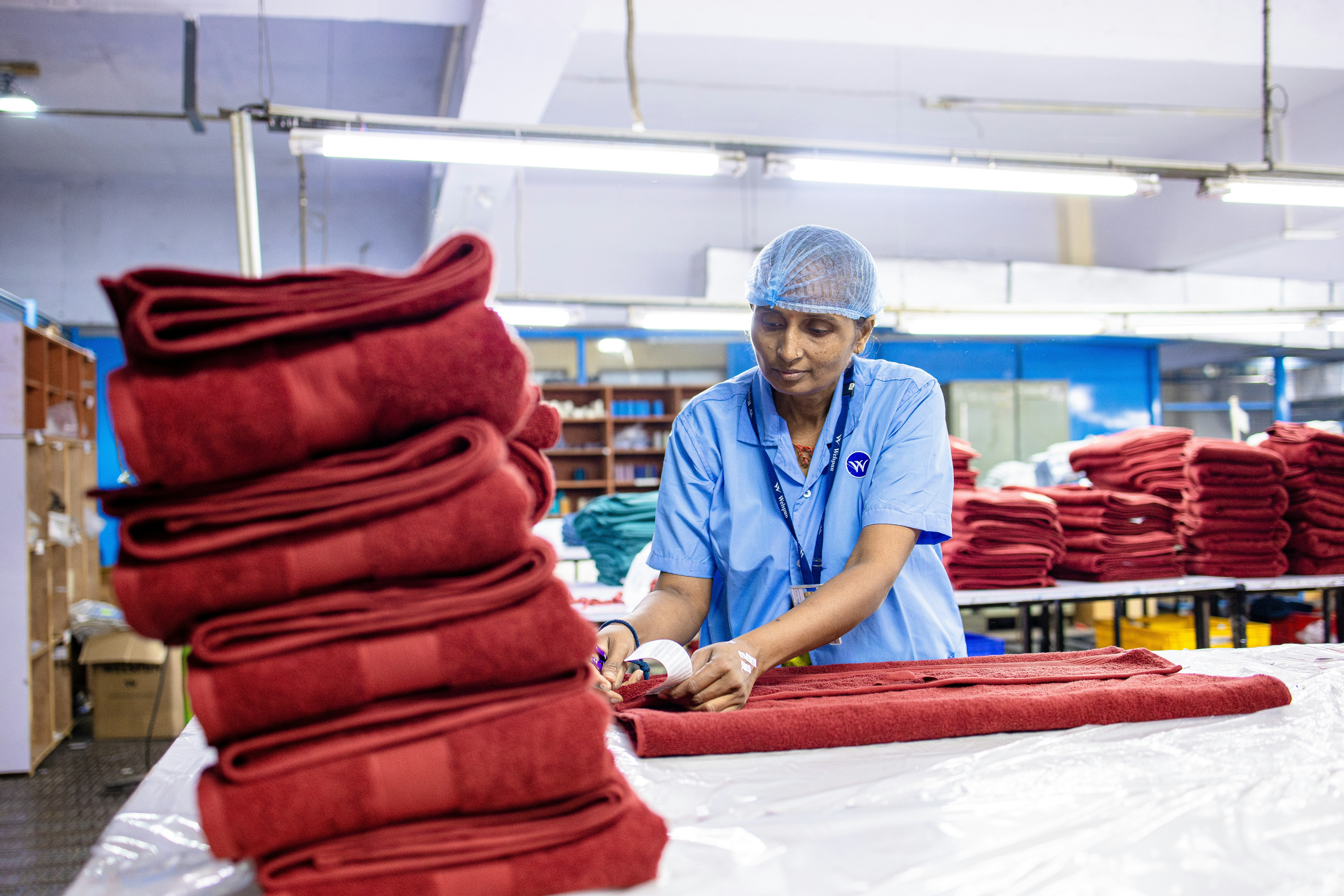 Worker folds towels in a factory setting