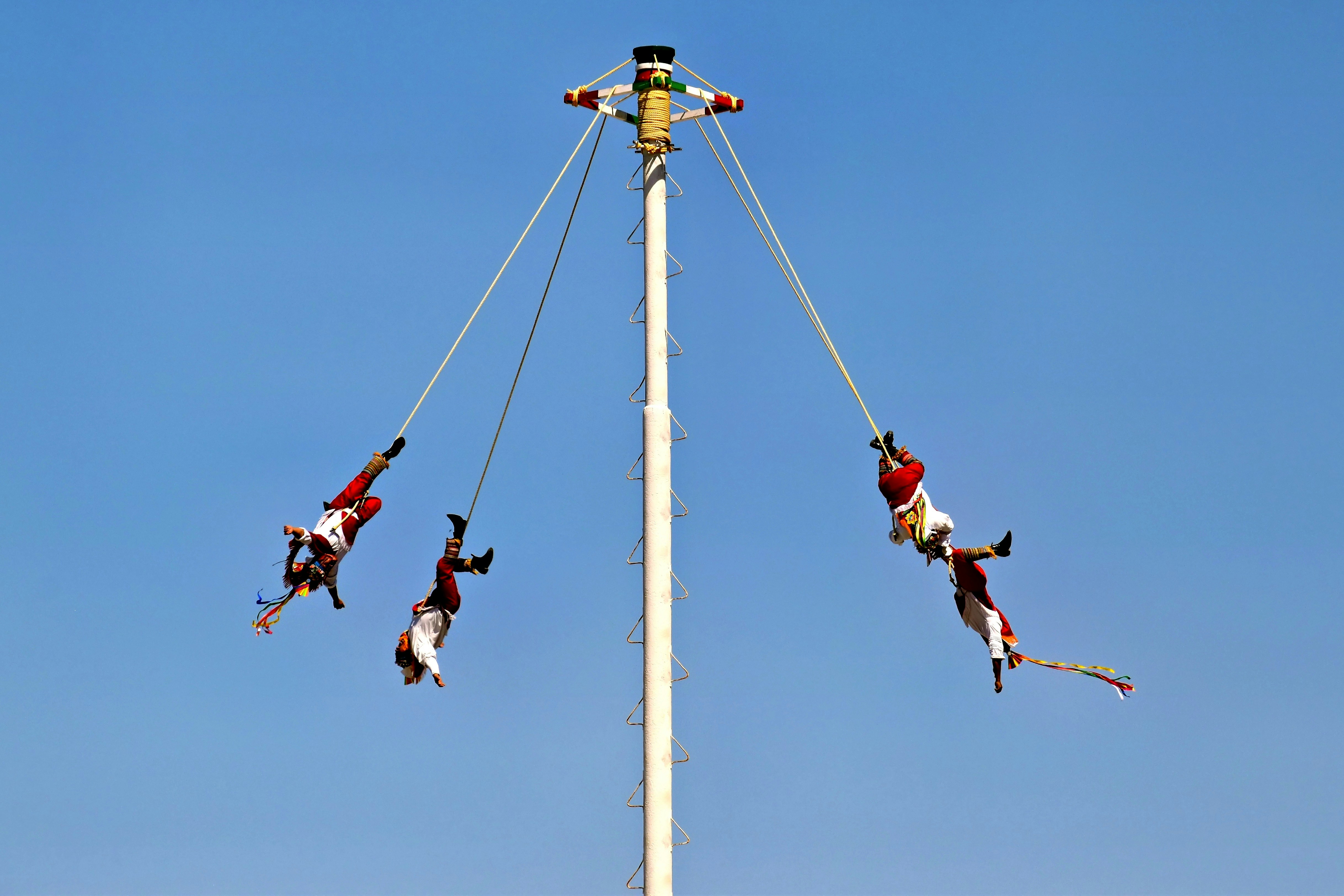 People are performing a traditional pole dance.