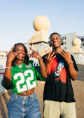 Two young people posing and making hand signs.