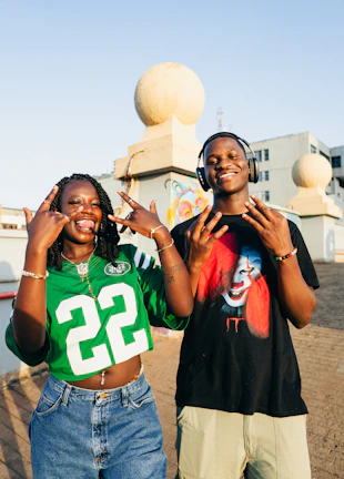 Two young people posing and making hand signs.