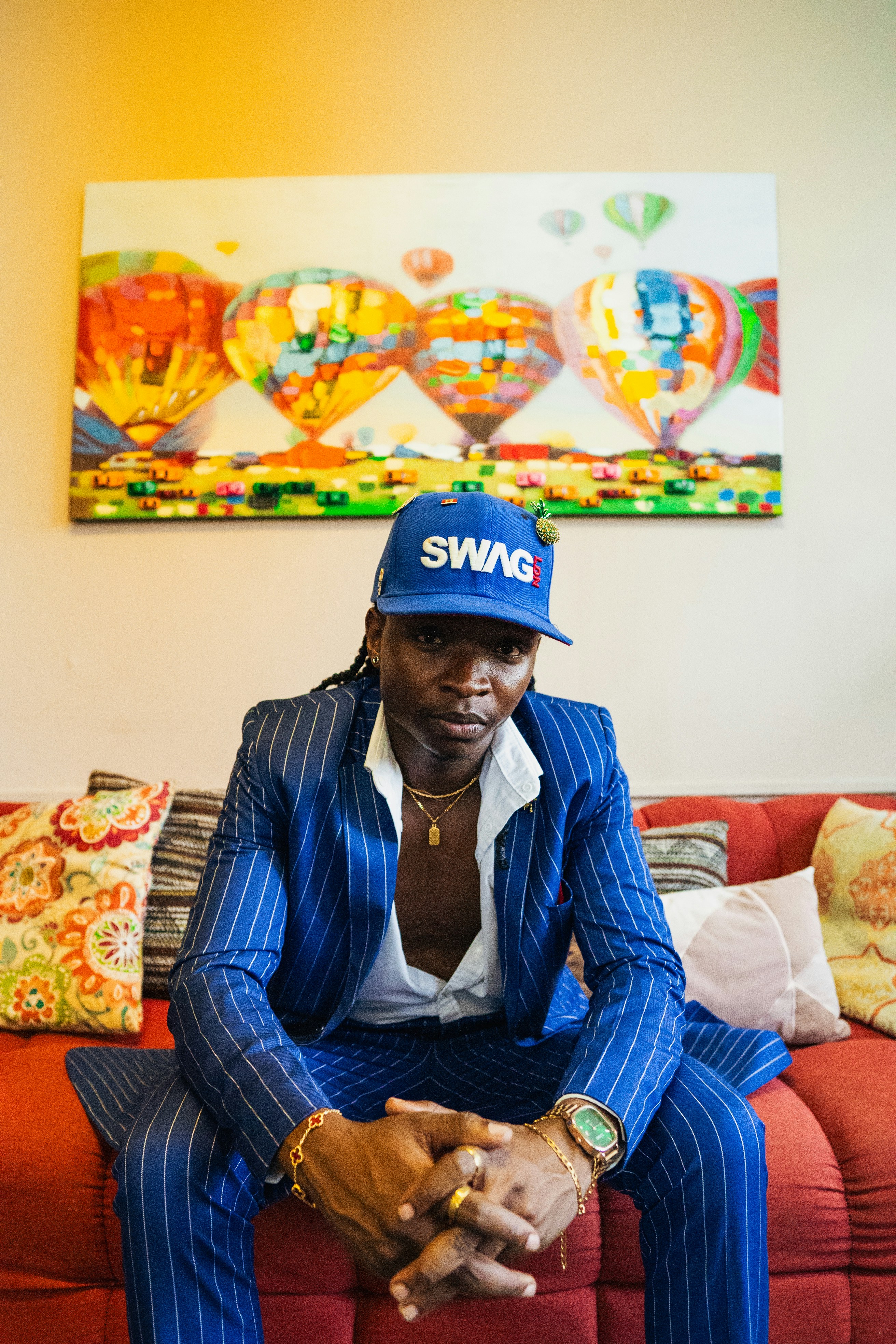 A man poses in front of colorful balloons.