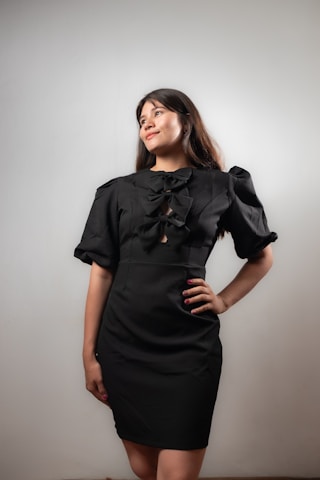 Woman poses in a black dress.