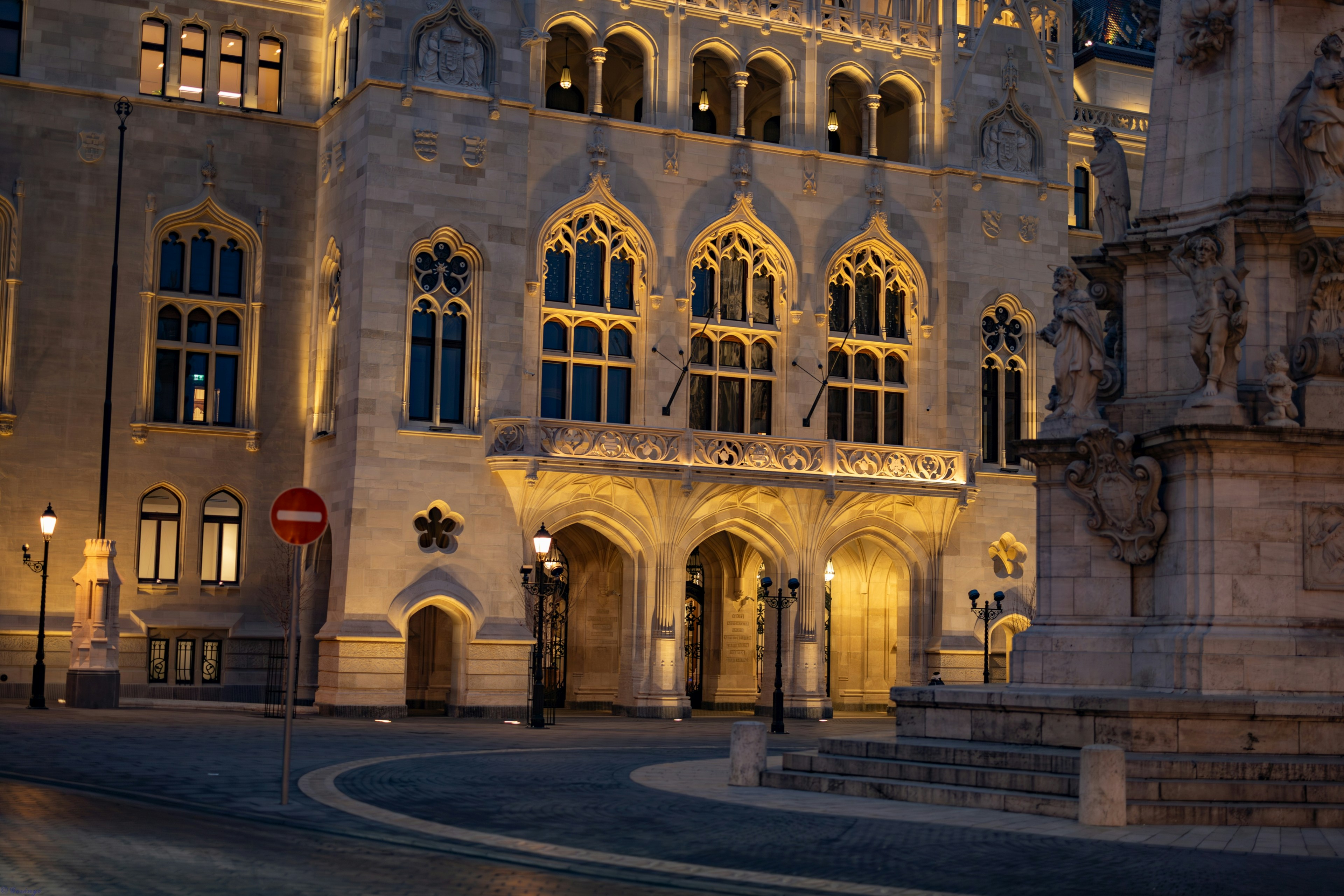 A lit-up ornate building at dusk.