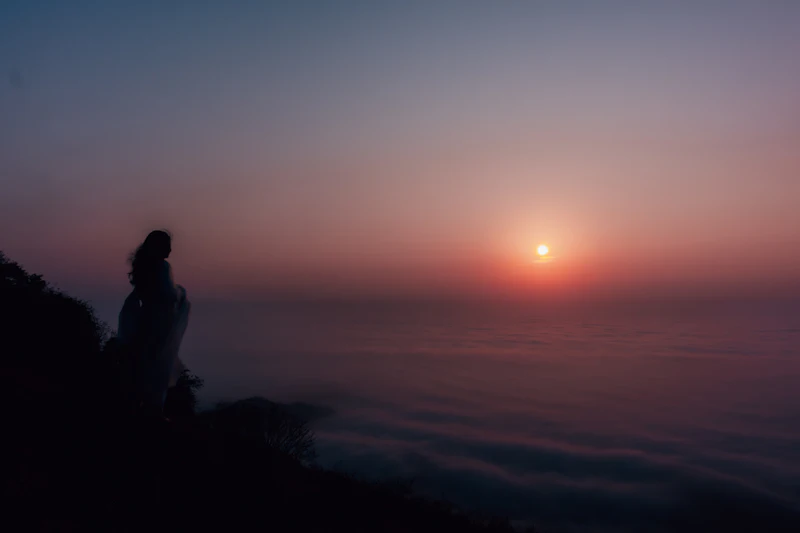 Person watching the sunrise above the clouds