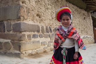 A young girl in traditional peruvian clothing.