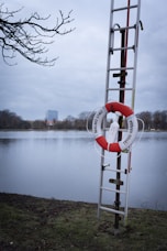Life ring and ladder stand ready by the water.