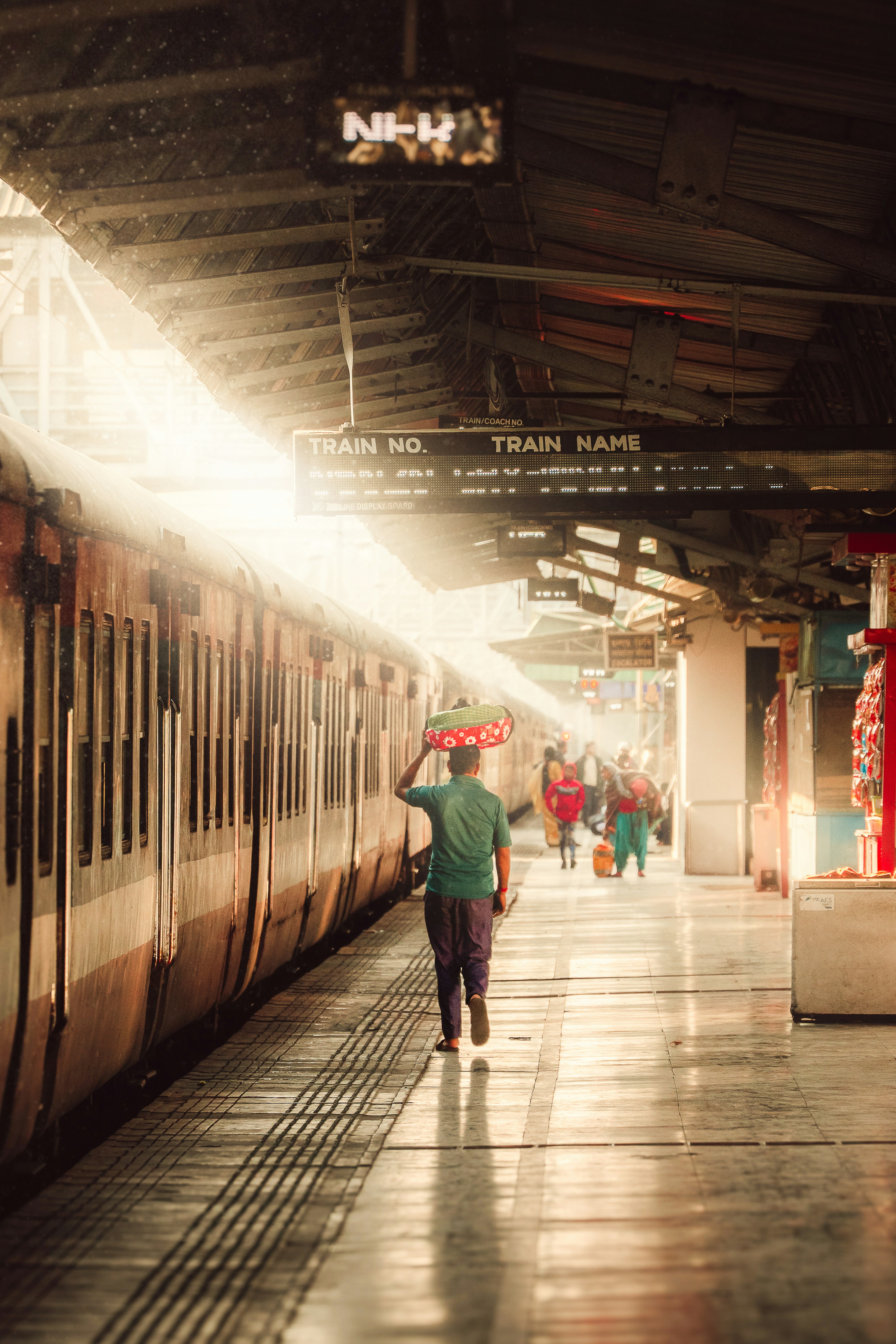 A man walks down a train station platform.