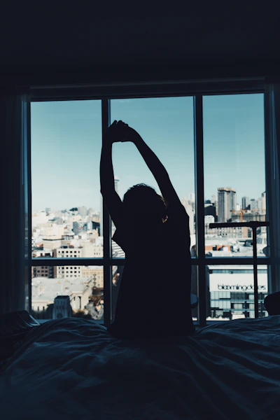 Person stretches near a city view window.