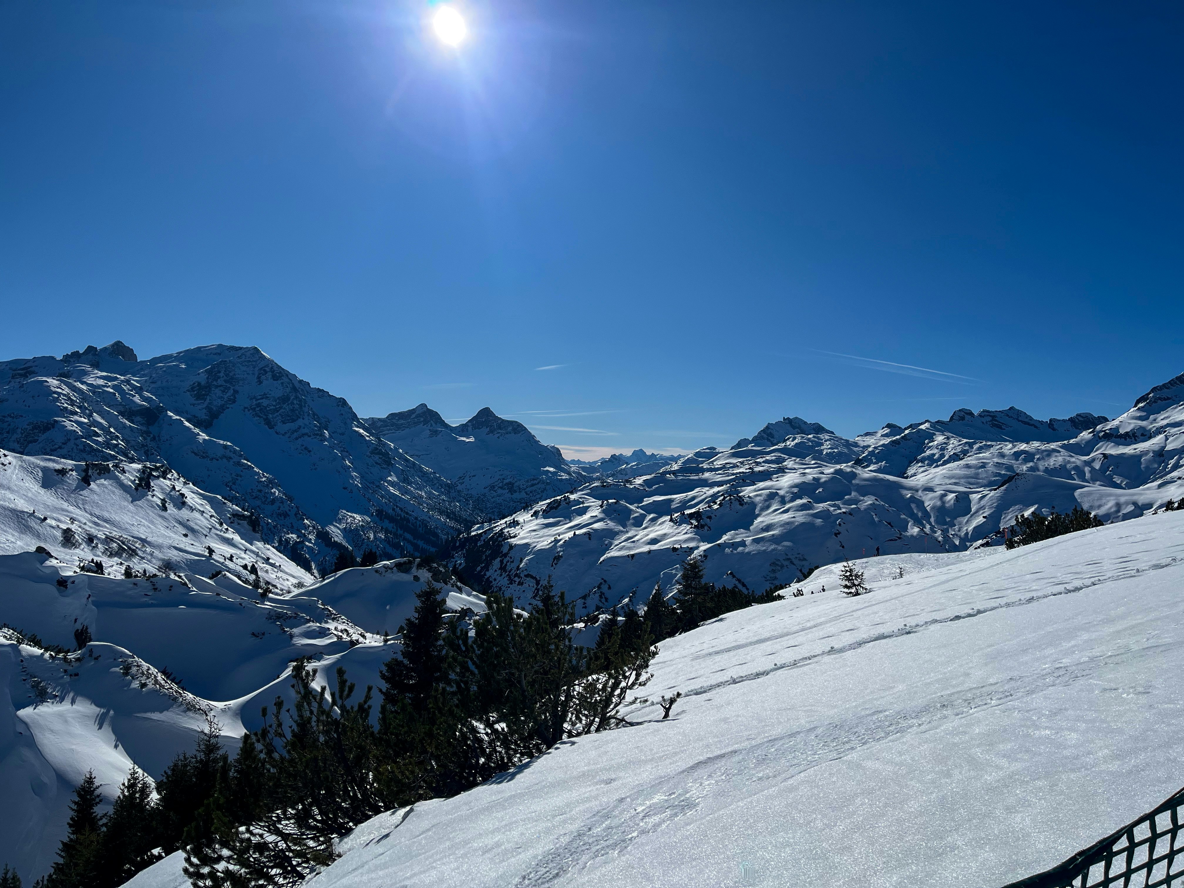 Snow-covered mountains under a bright, sunny sky.