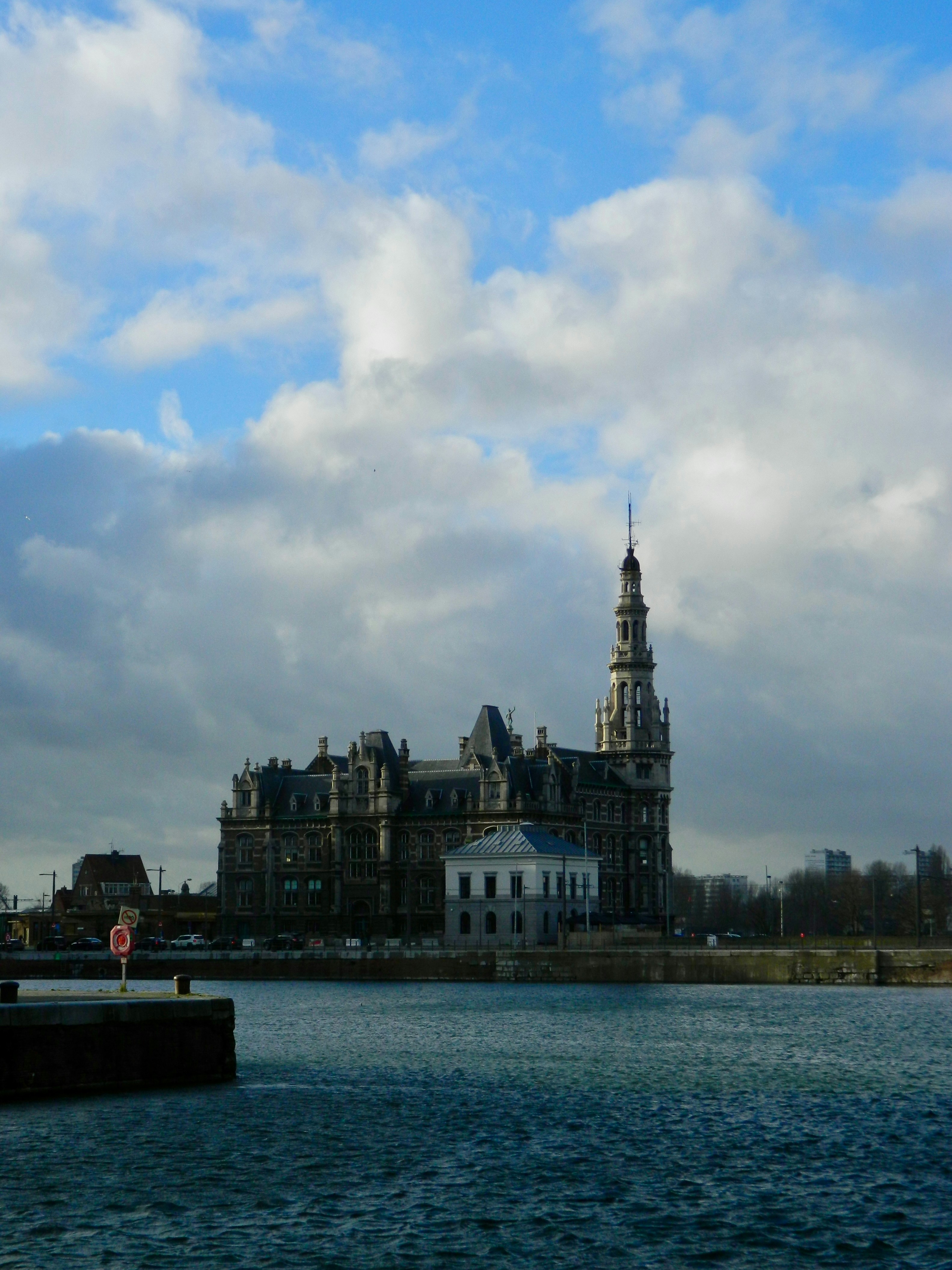 Elegant architecture stands by the water under cloudy skies.