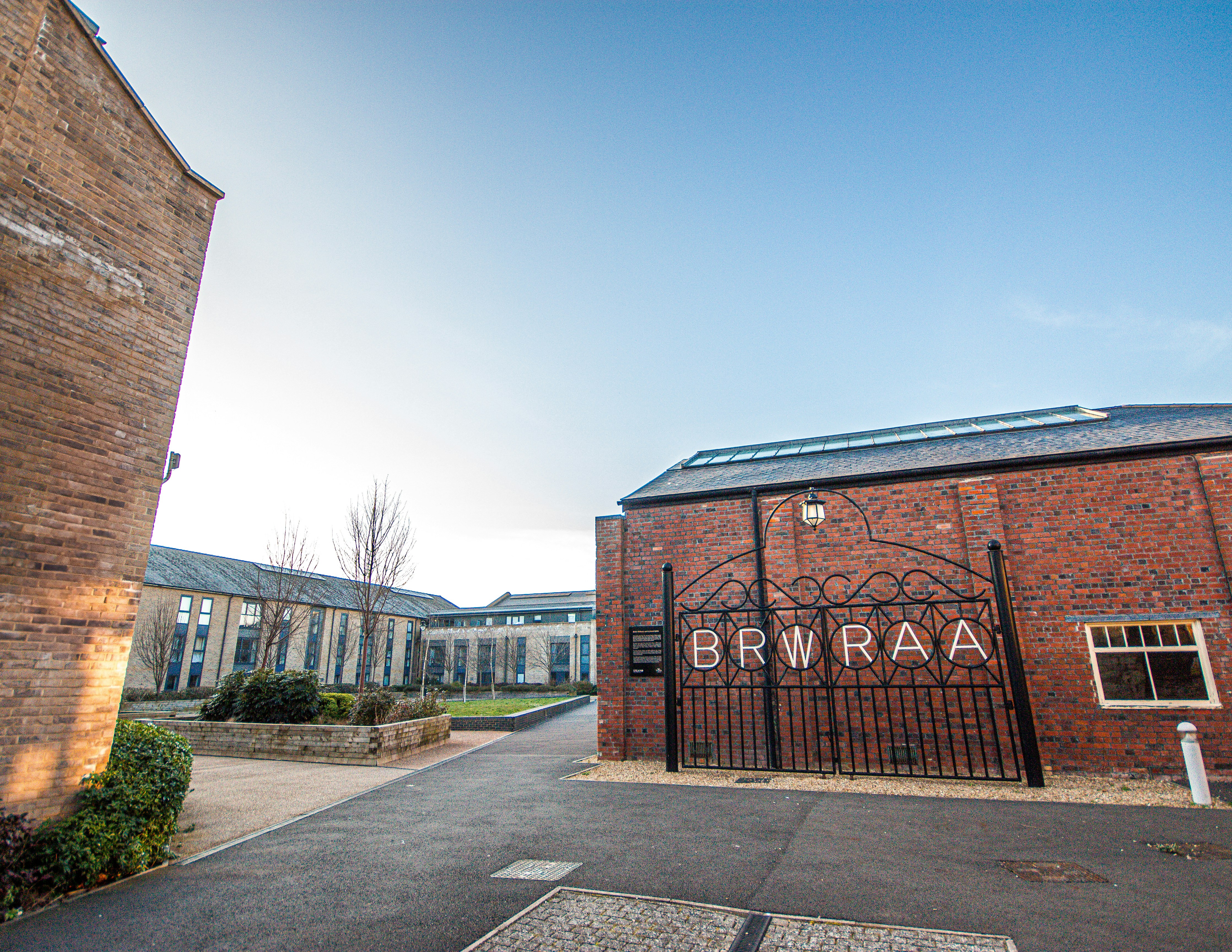 A brick building entrance with the words "brwraa".