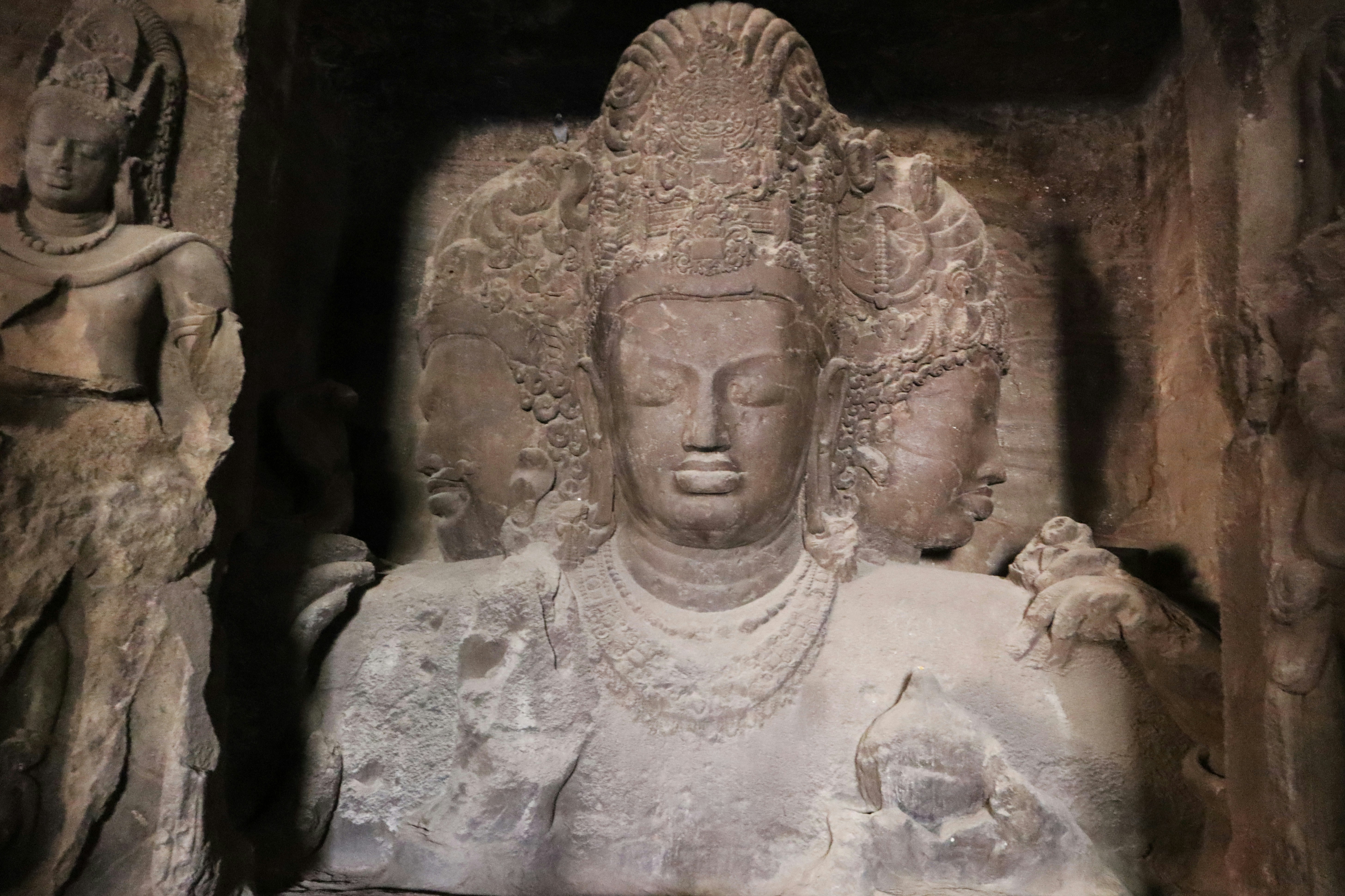 A stone sculpture of a deity in a cave.