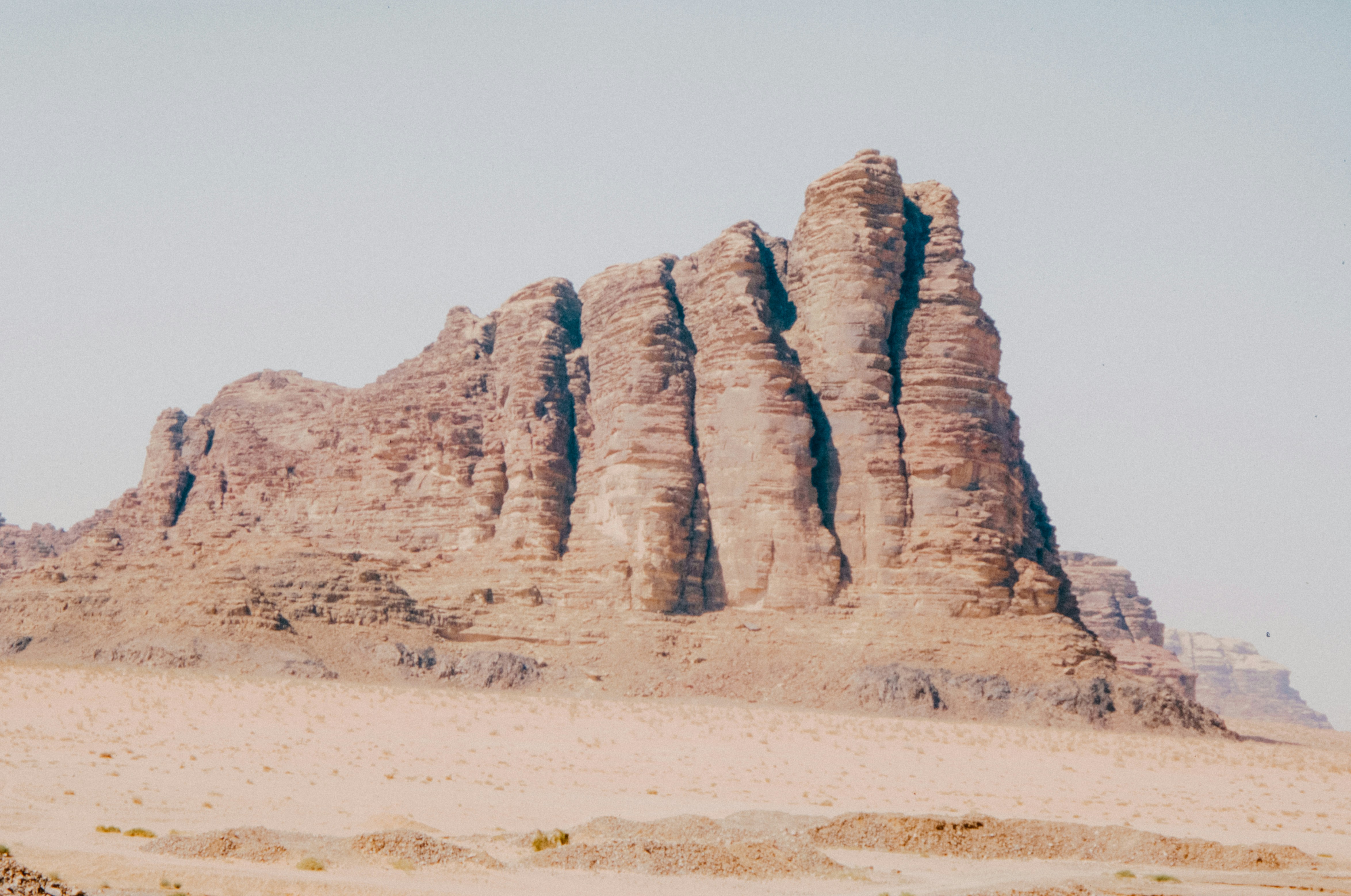 A rugged rock formation stands in the desert.