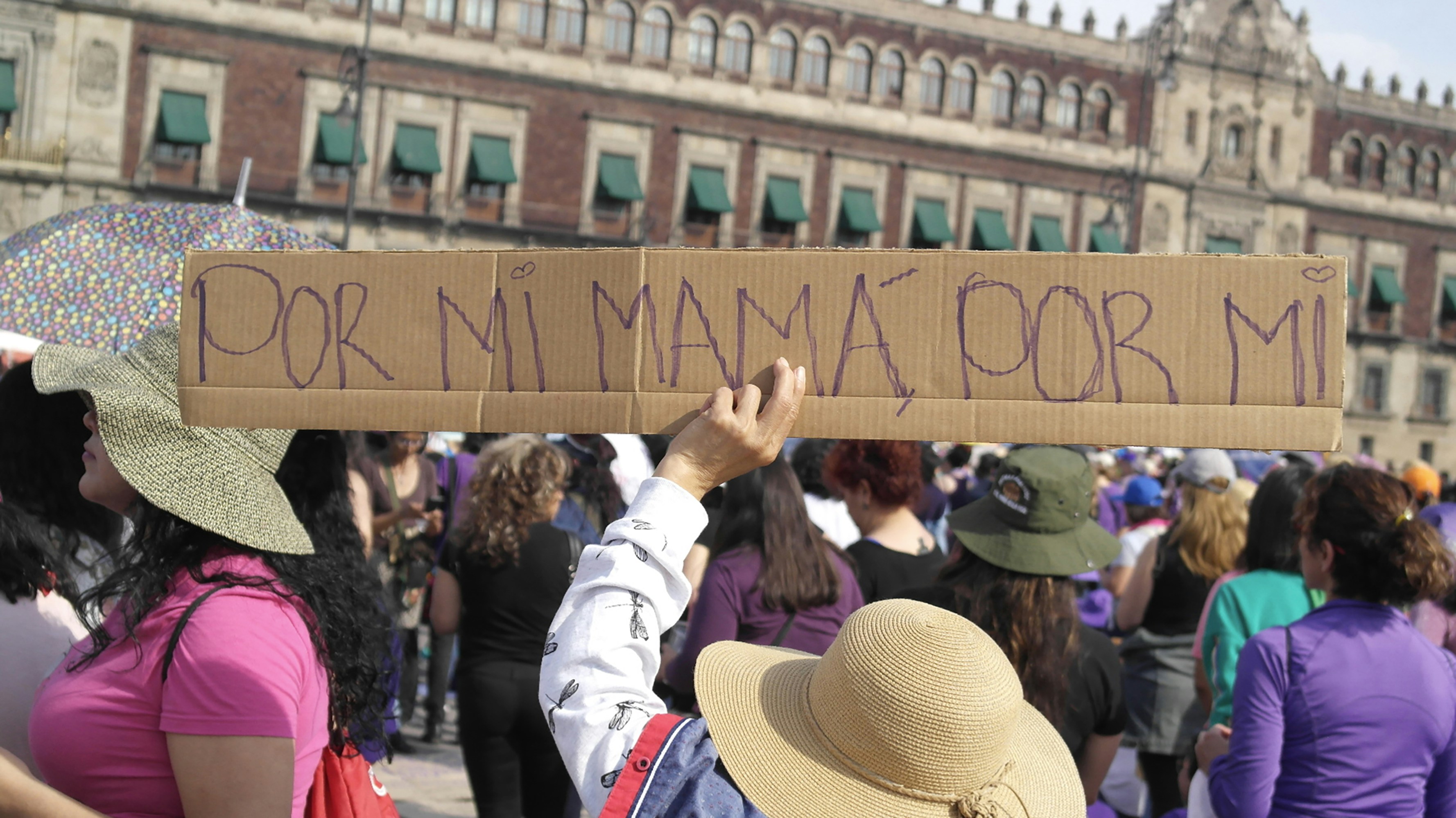 Women protest holding a sign in spanish.