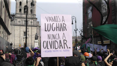 Protest sign reads: "we will fight, never forget."