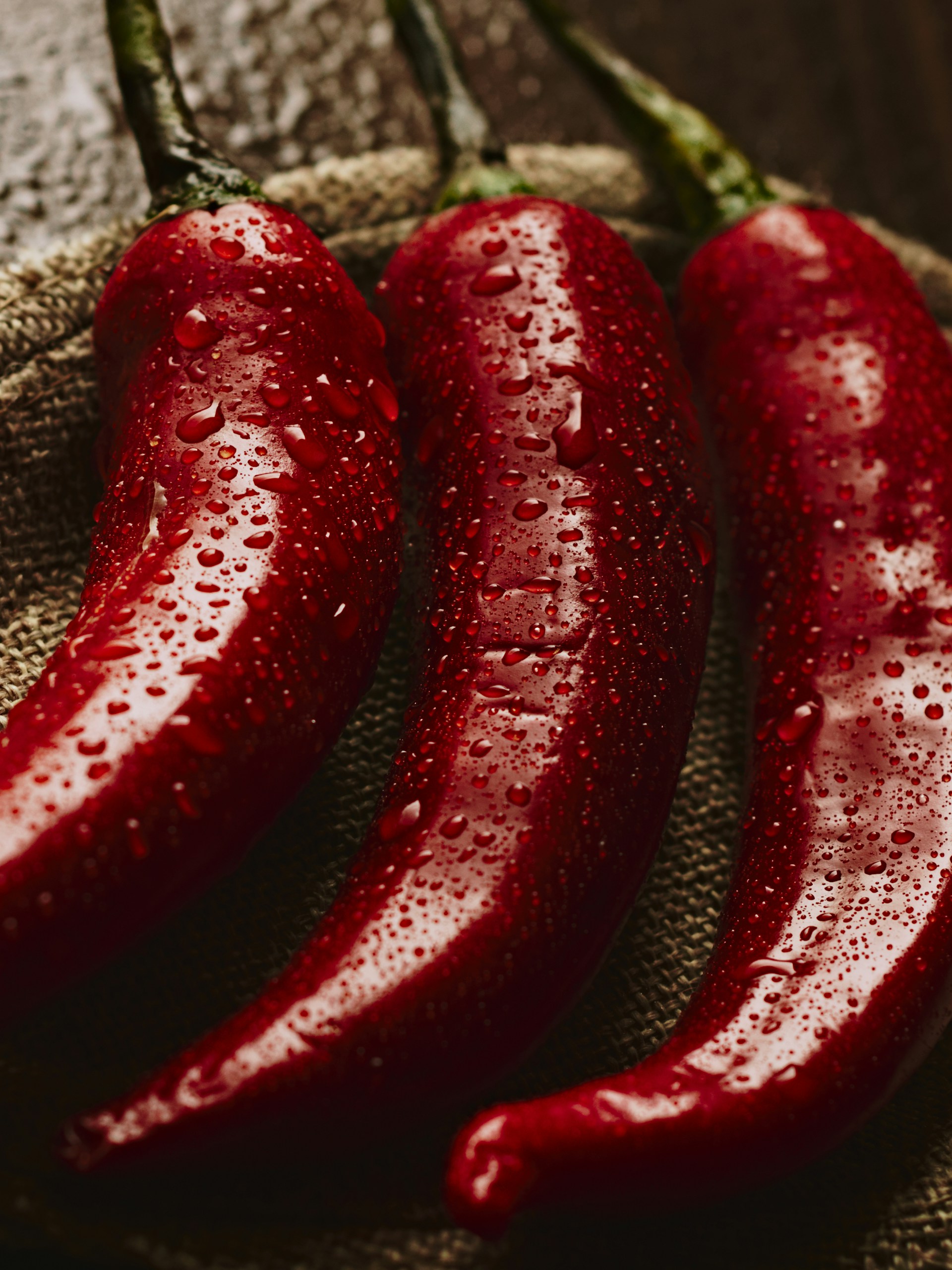 Red chili peppers glistens with water droplets.