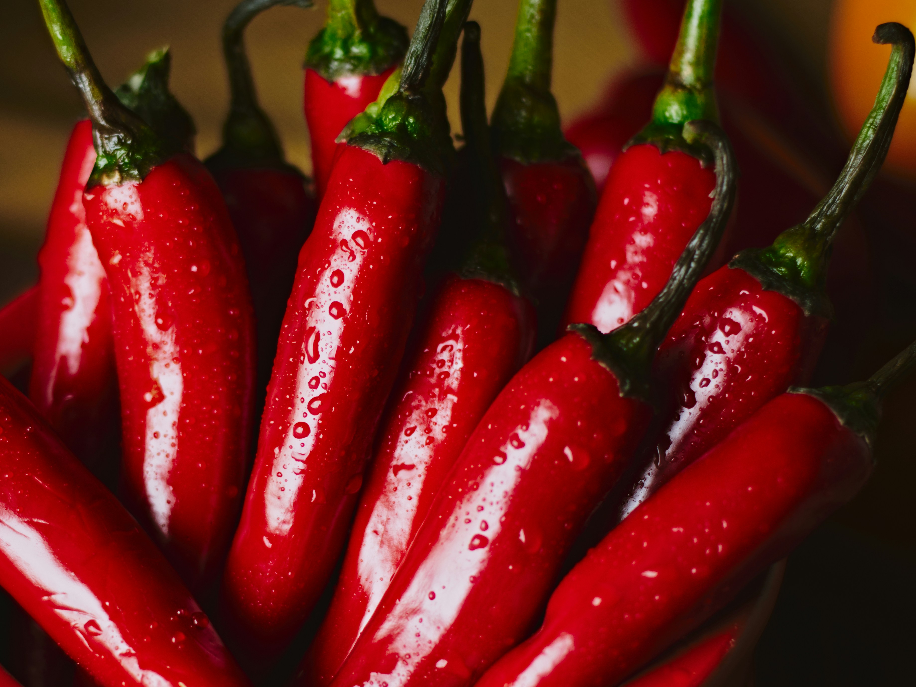 Red chili peppers are clustered together.