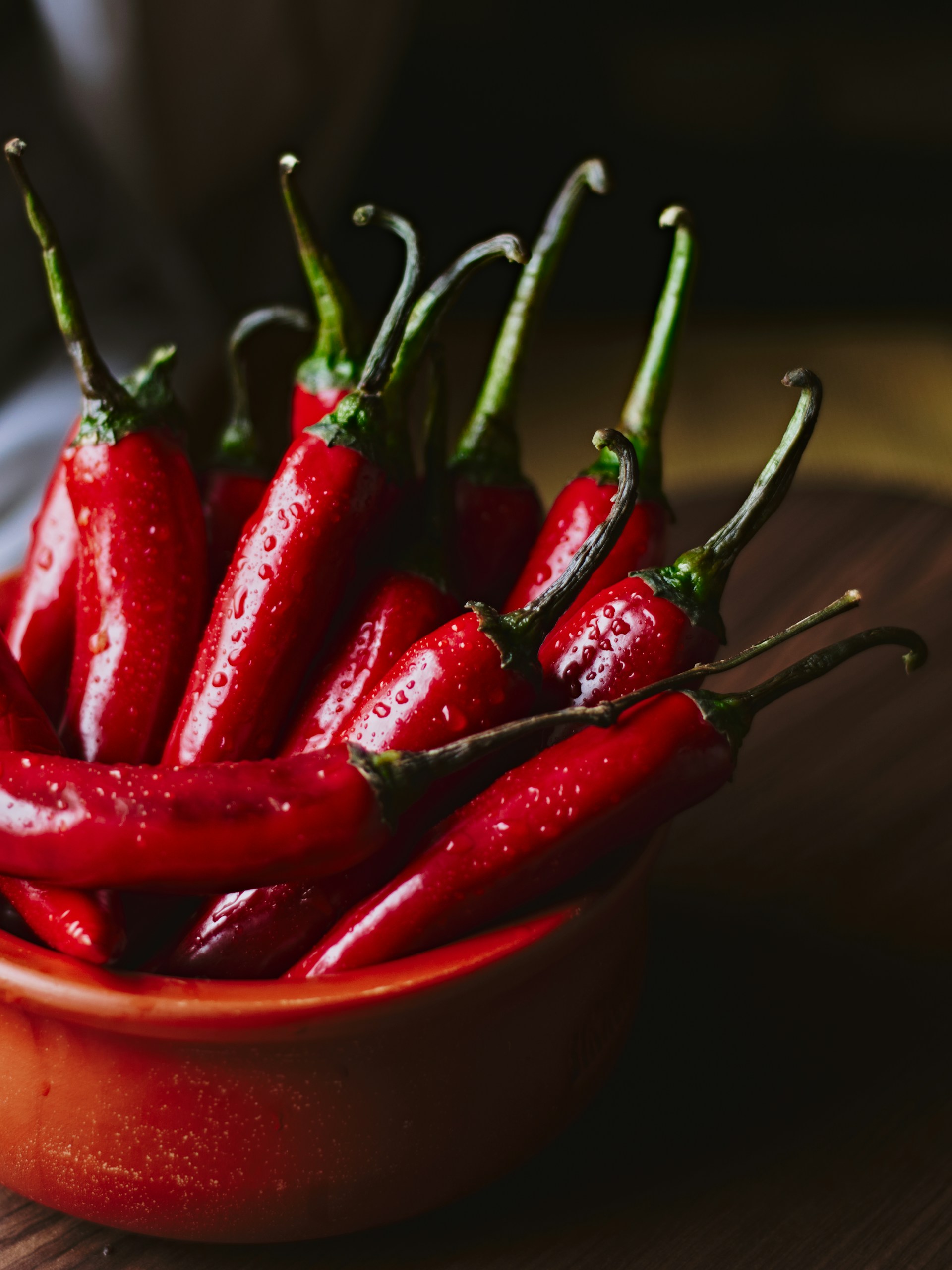Red hot chili peppers in a rustic ceramic bowl.