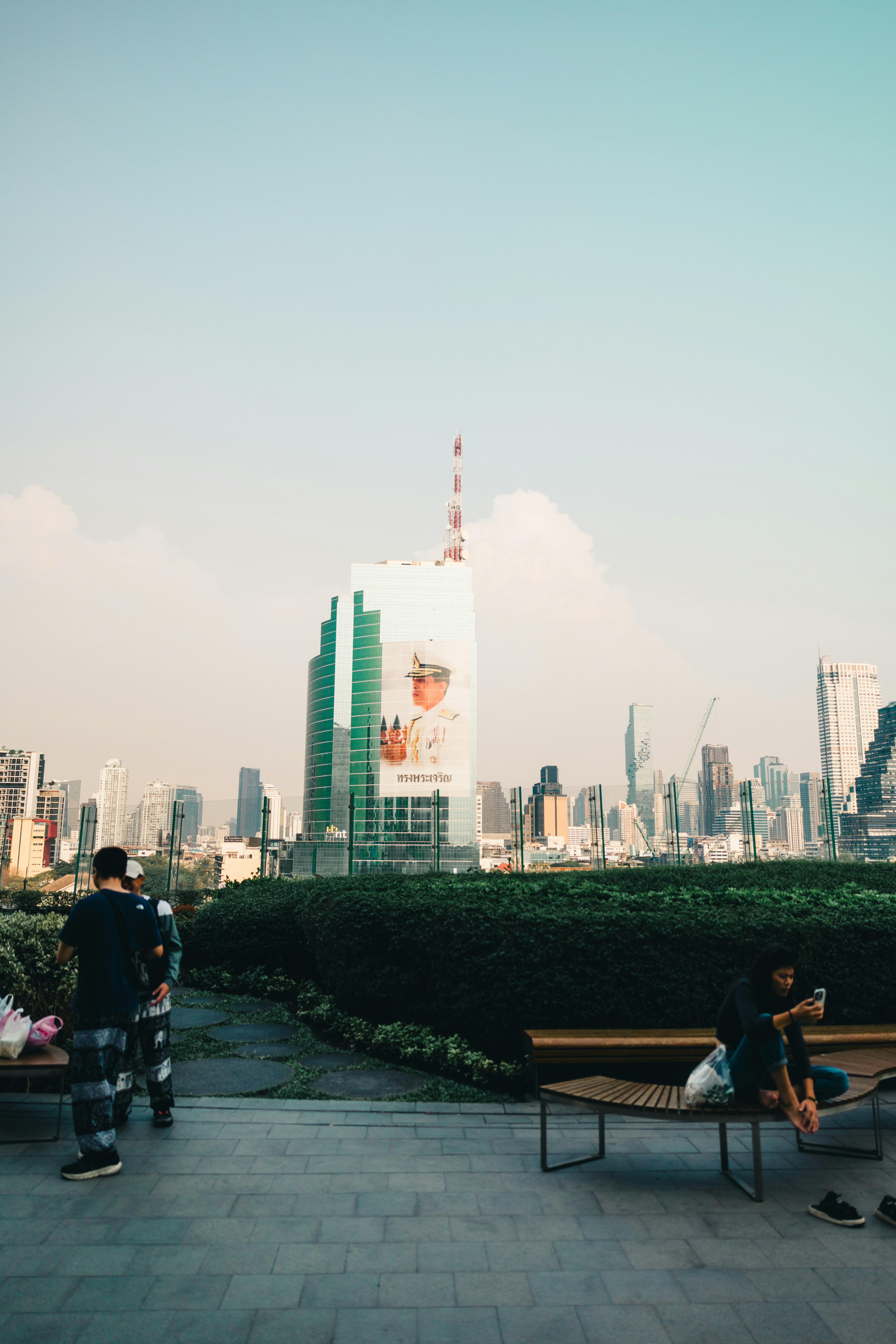Bangkok city skyline seen through green park trees