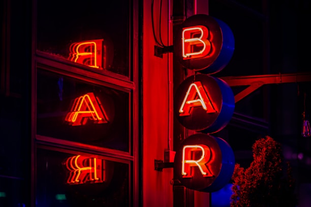 The illuminated neon sign spells out "bar."