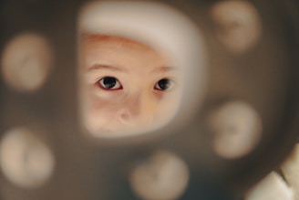 A child peers through a peephole.
