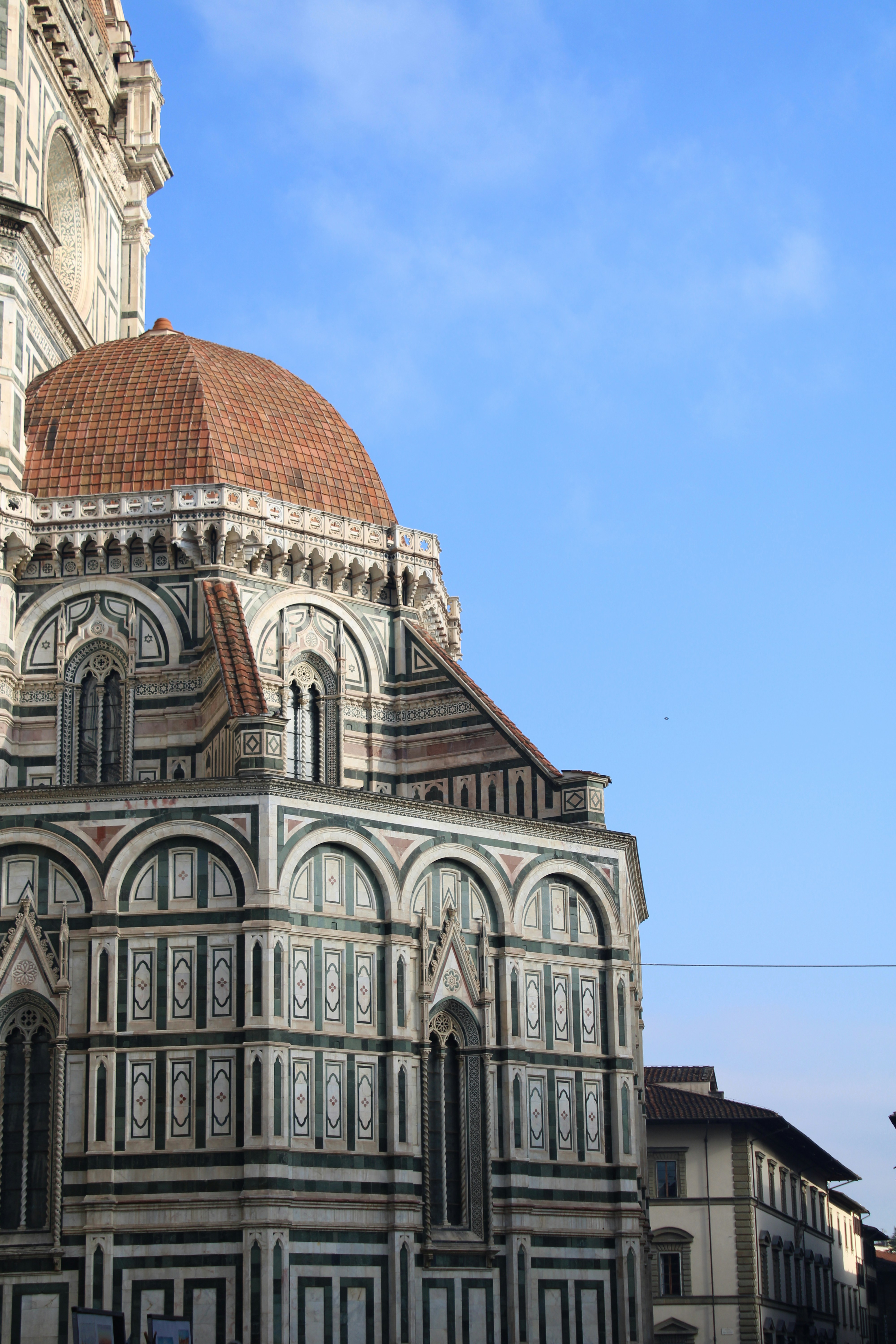 The florence cathedral stands against a blue sky.