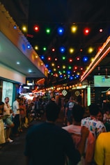 Crowded street lit up with colorful lights.