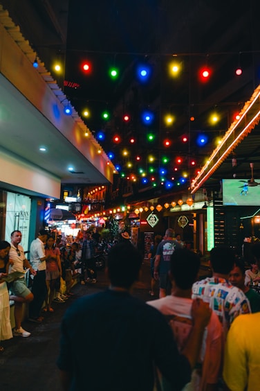 Crowded street lit up with colorful lights.