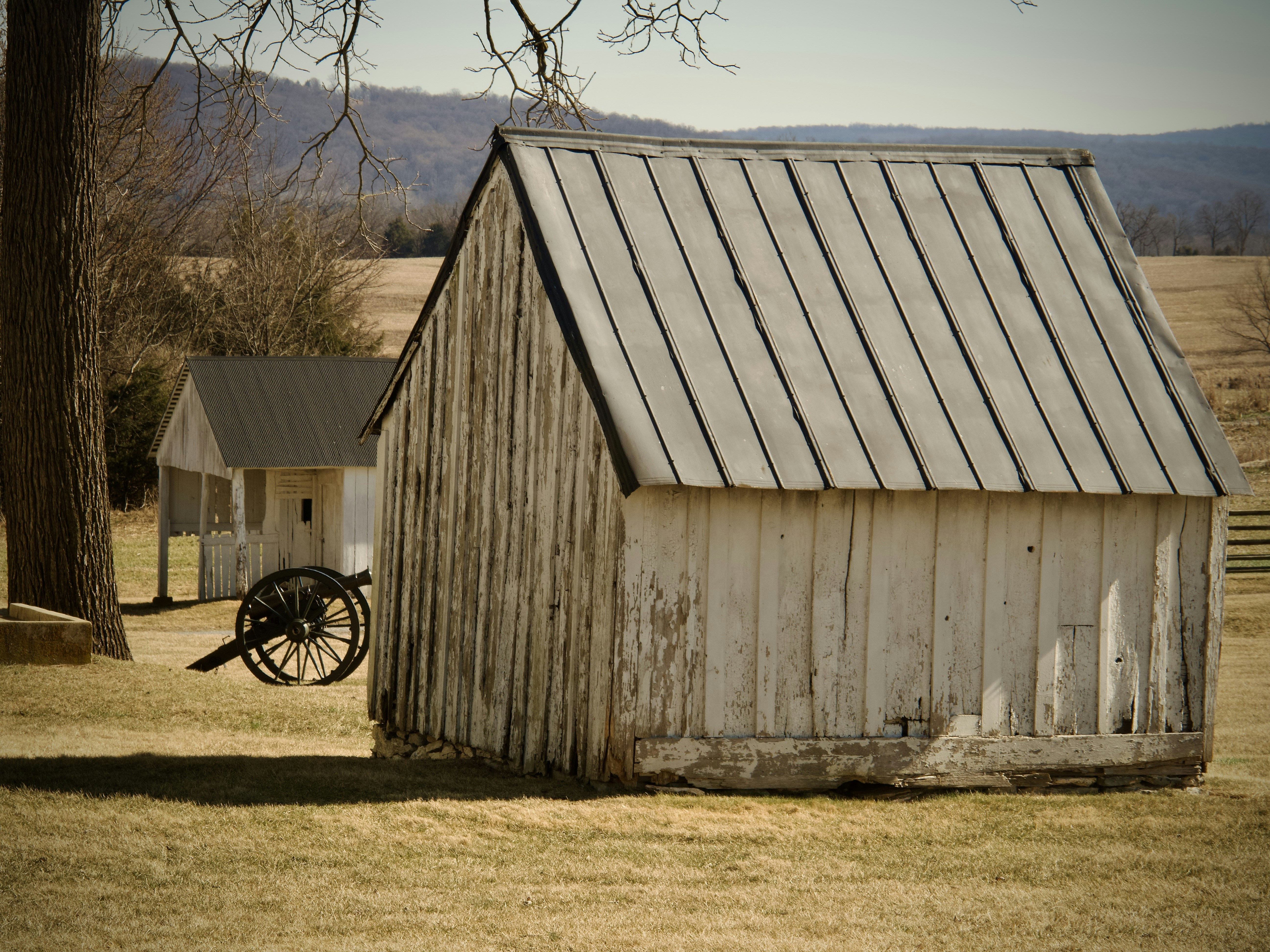 Historical buildings and a cannon on a field.