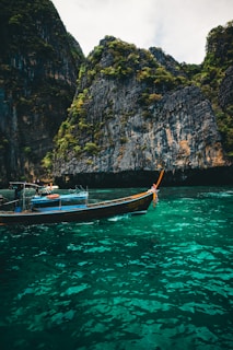 Boat sailing by cliffs and turquoise waters.
