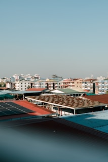 City rooftops and buildings under a bright sky.