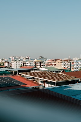 City rooftops and buildings under a bright sky.