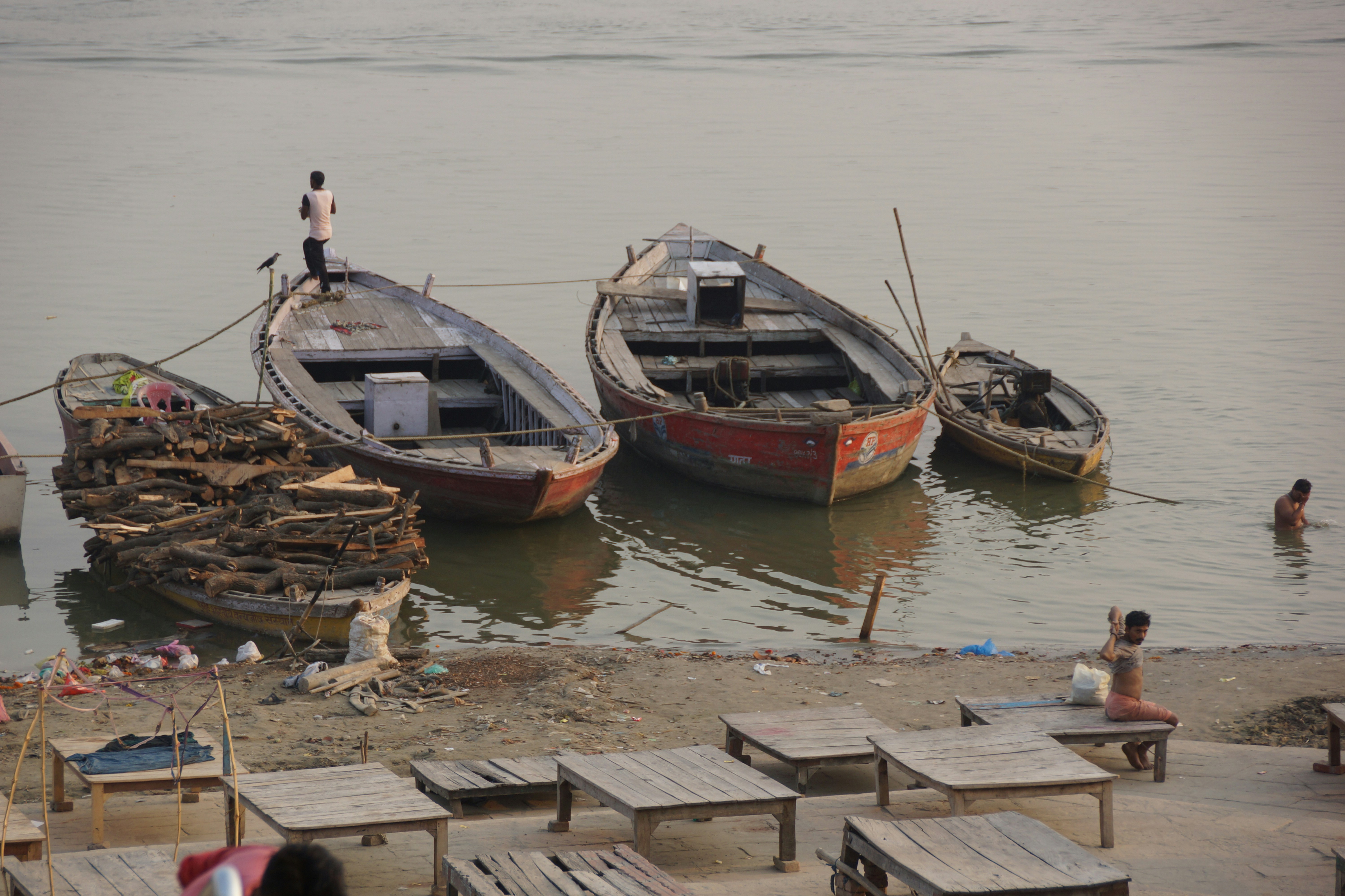Boats on riverbank with people