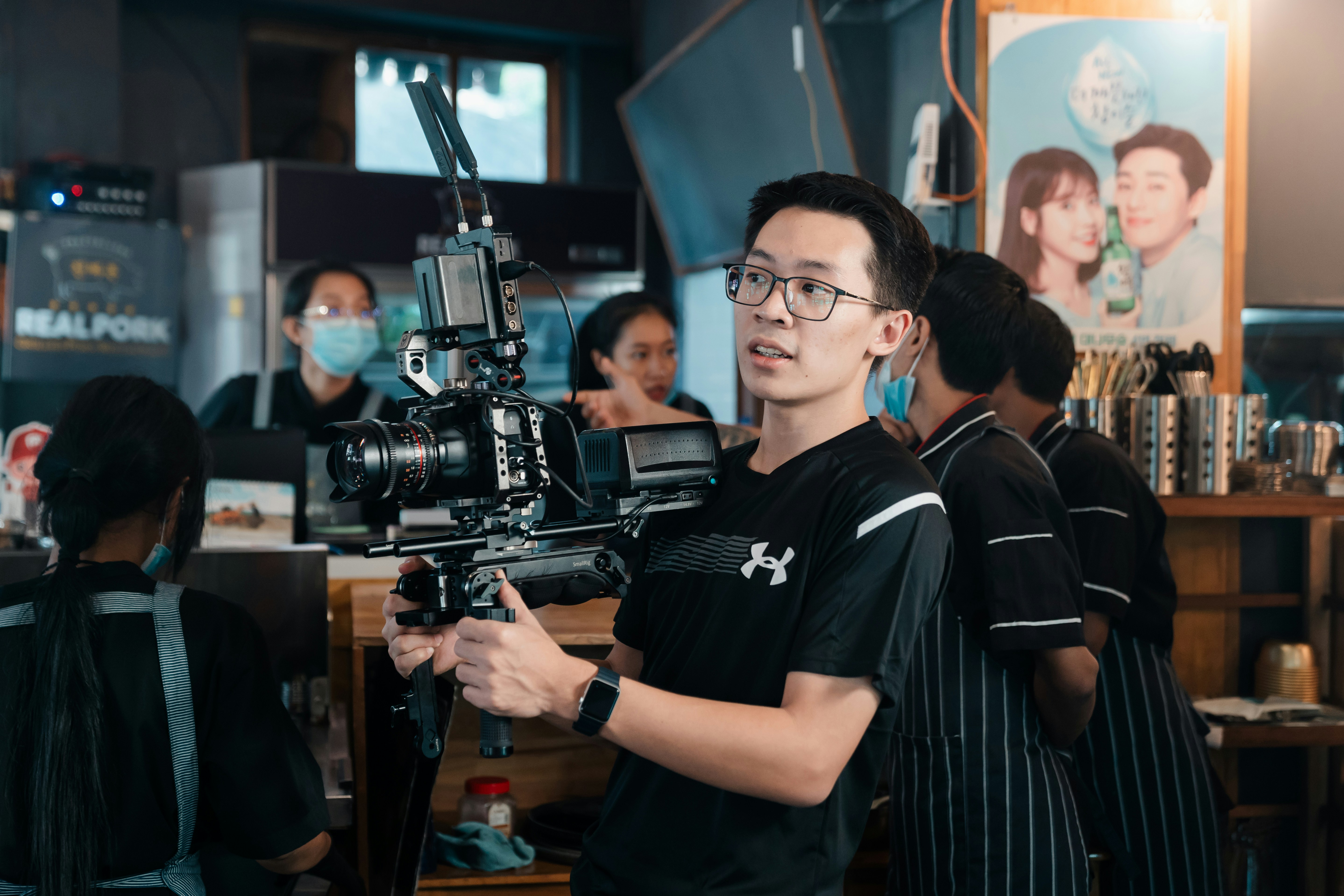 A man operates a camera for filming.