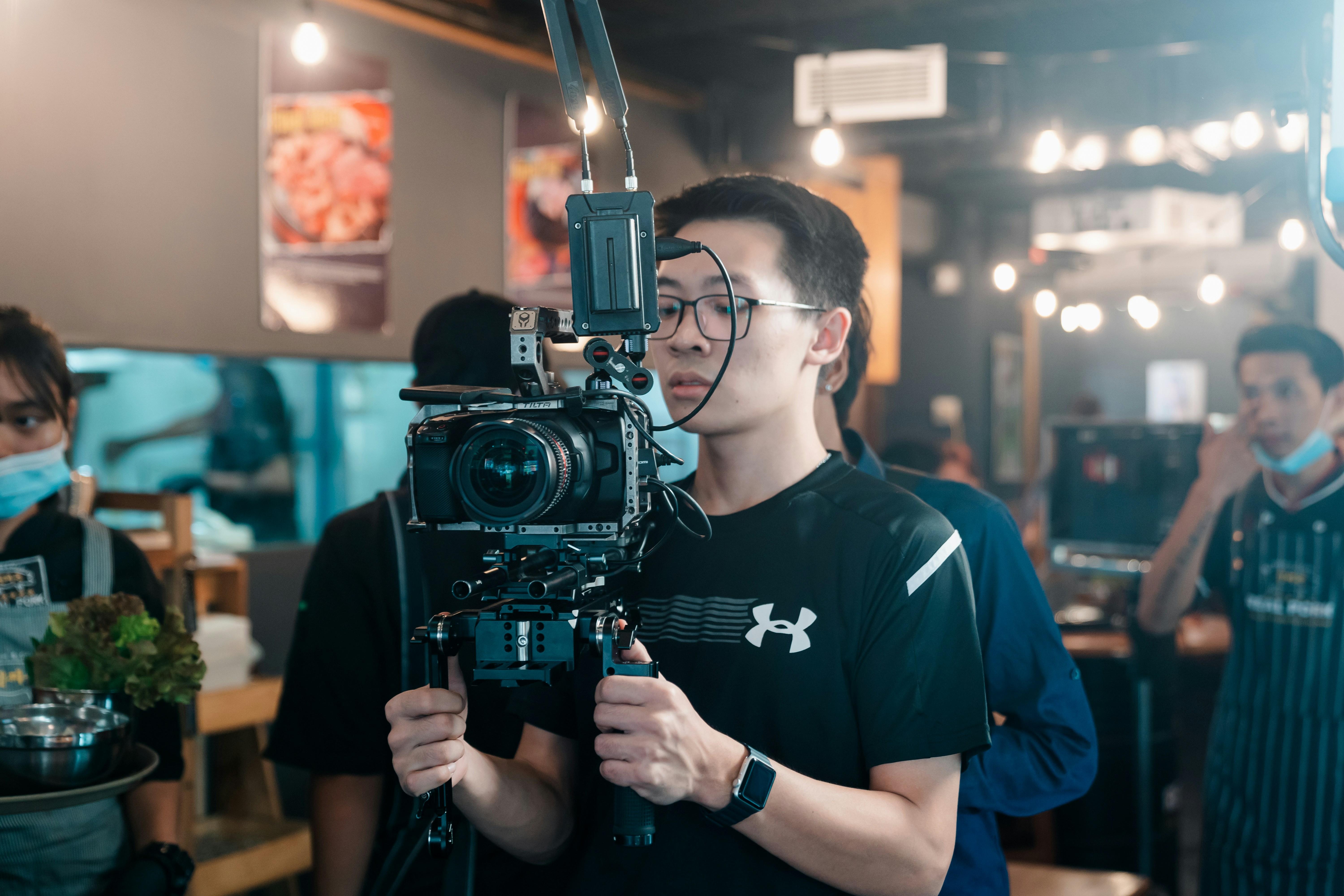 A cinematographer is filming in a restaurant.