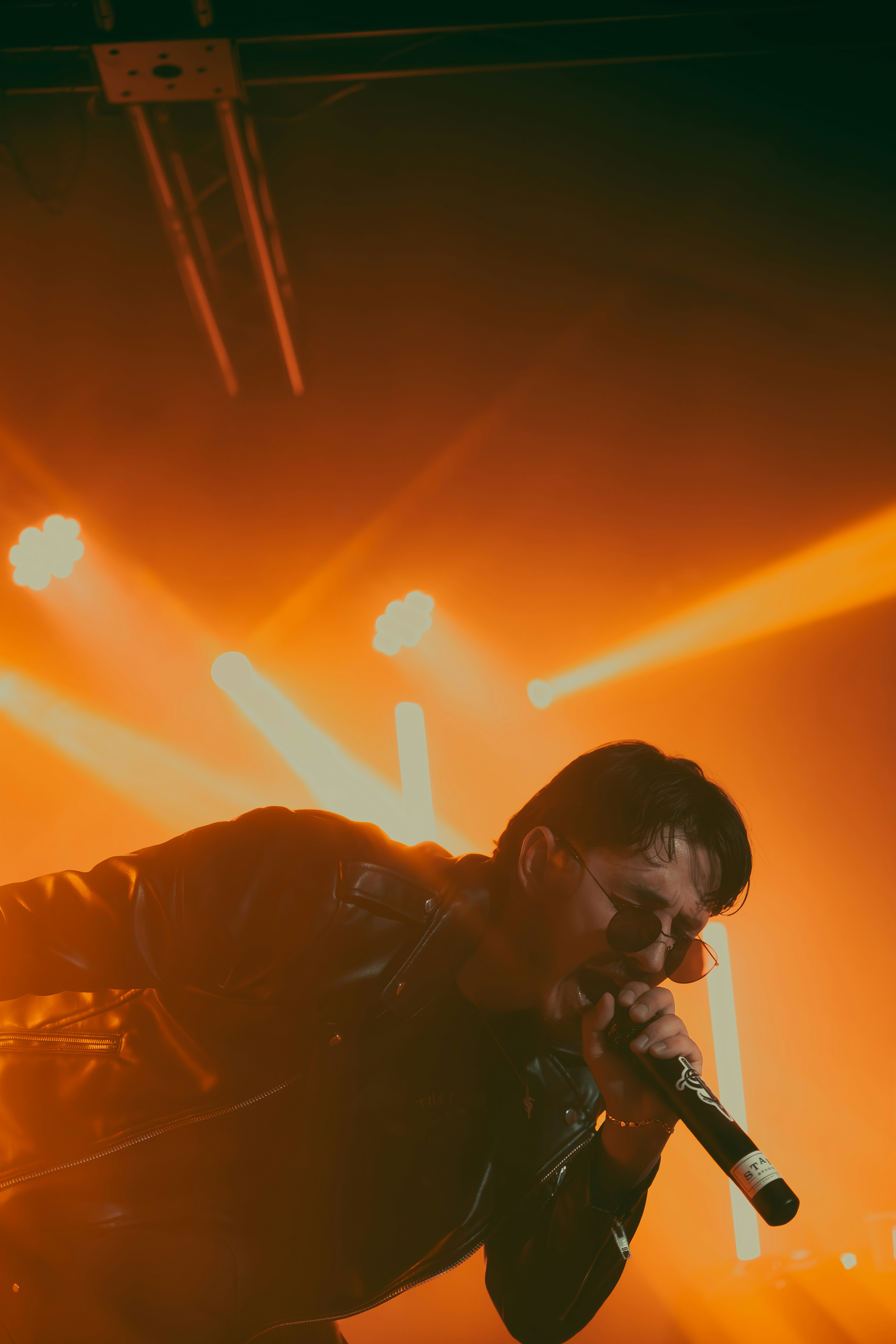 A man performs on stage with microphone.