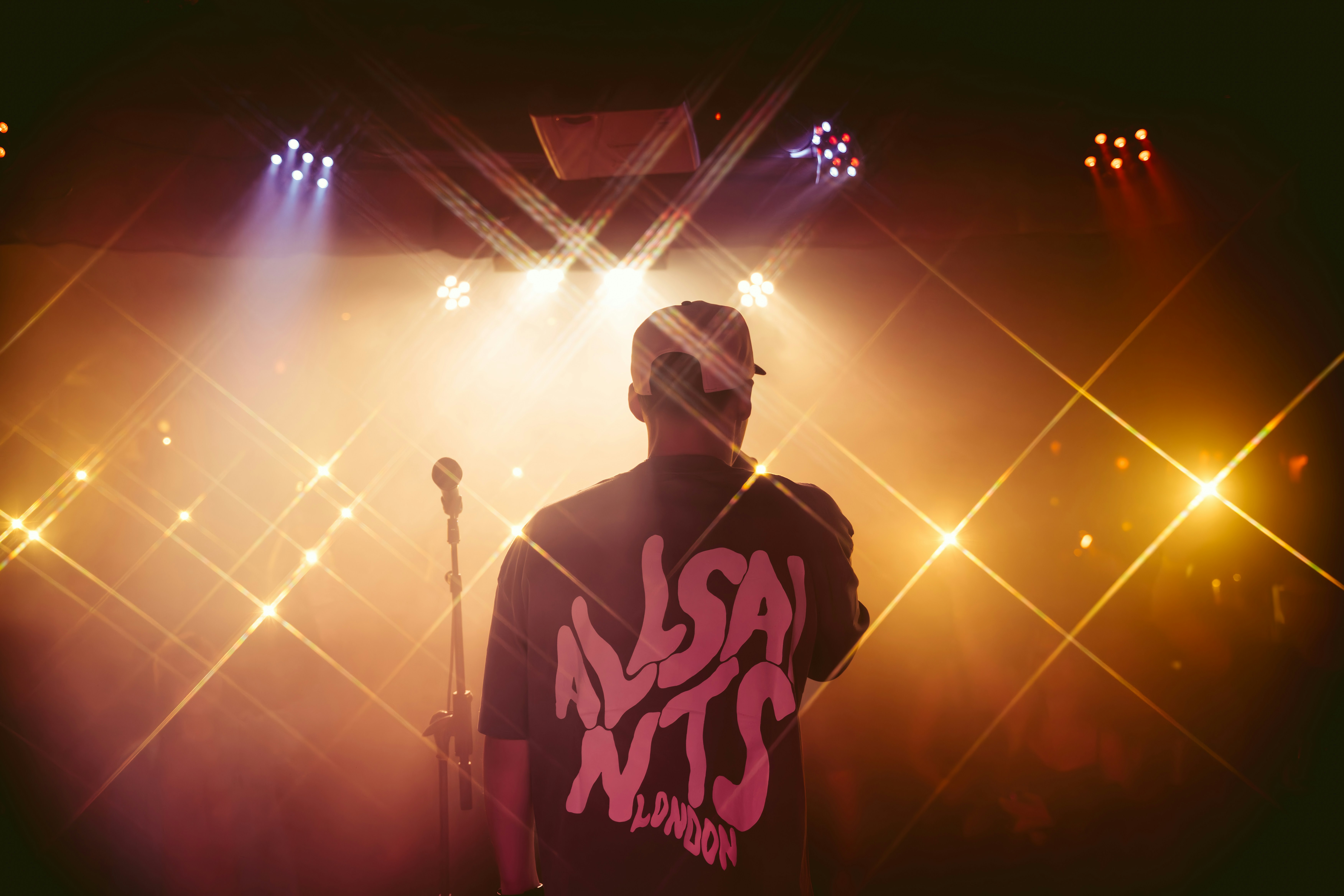 A performer on stage, bathed in bright light.