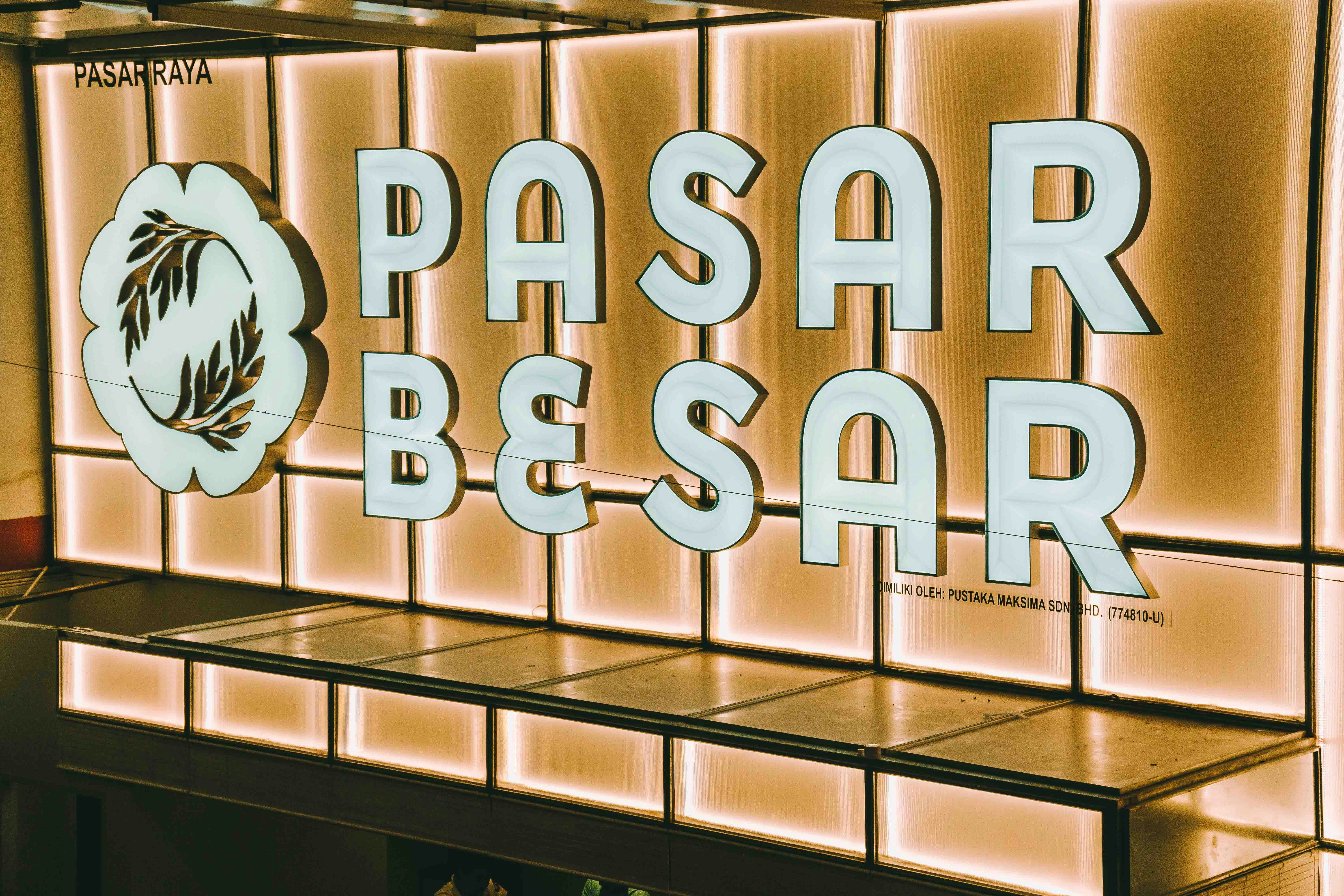 Pasar besar sign illuminated with warm light.
