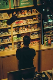 A person stands at a convenience store counter.