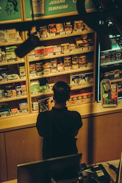 A person stands at a convenience store counter.