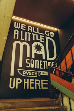 A wall mural states: "we all go a little mad."