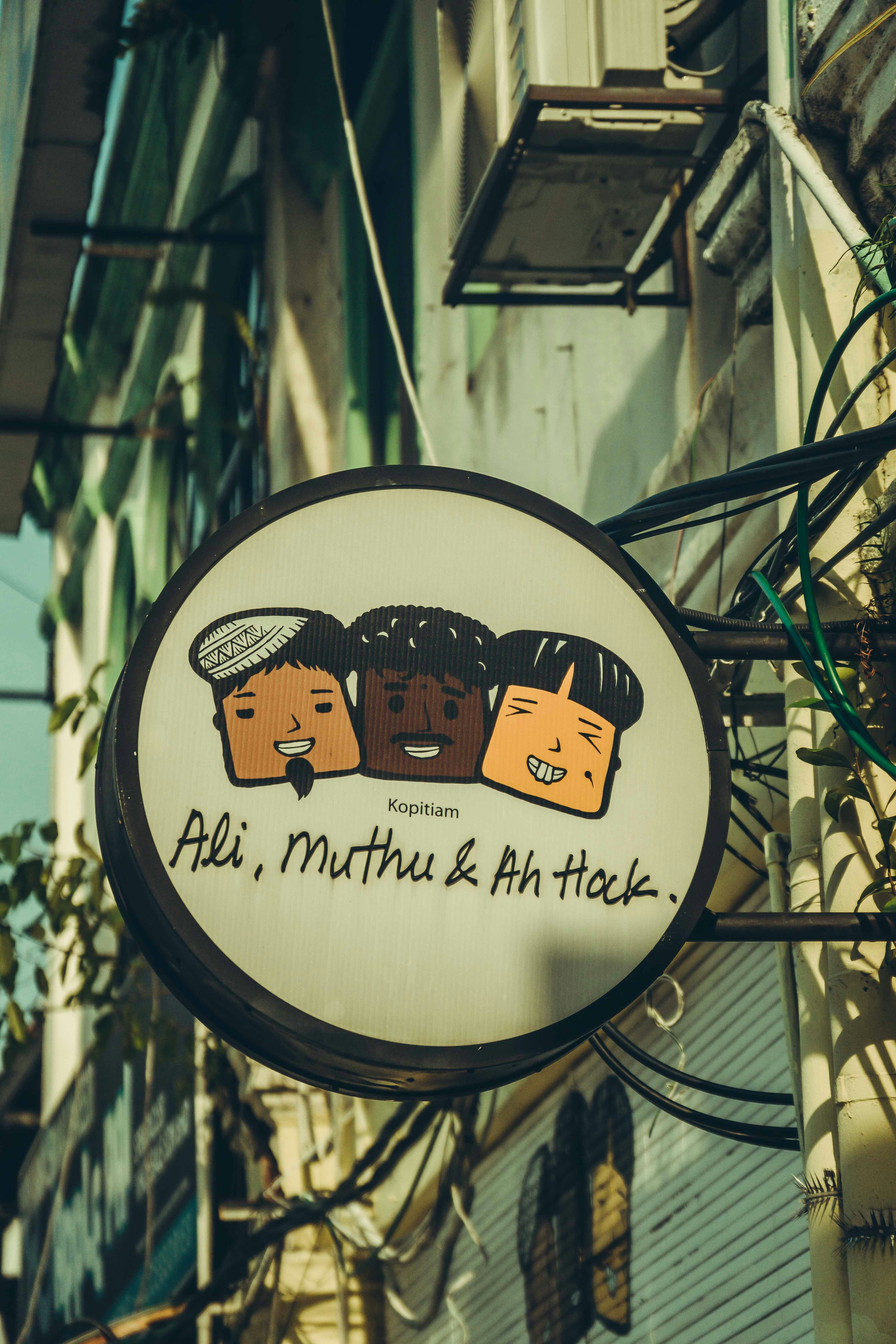 A coffee shop sign with diverse cartoon faces.